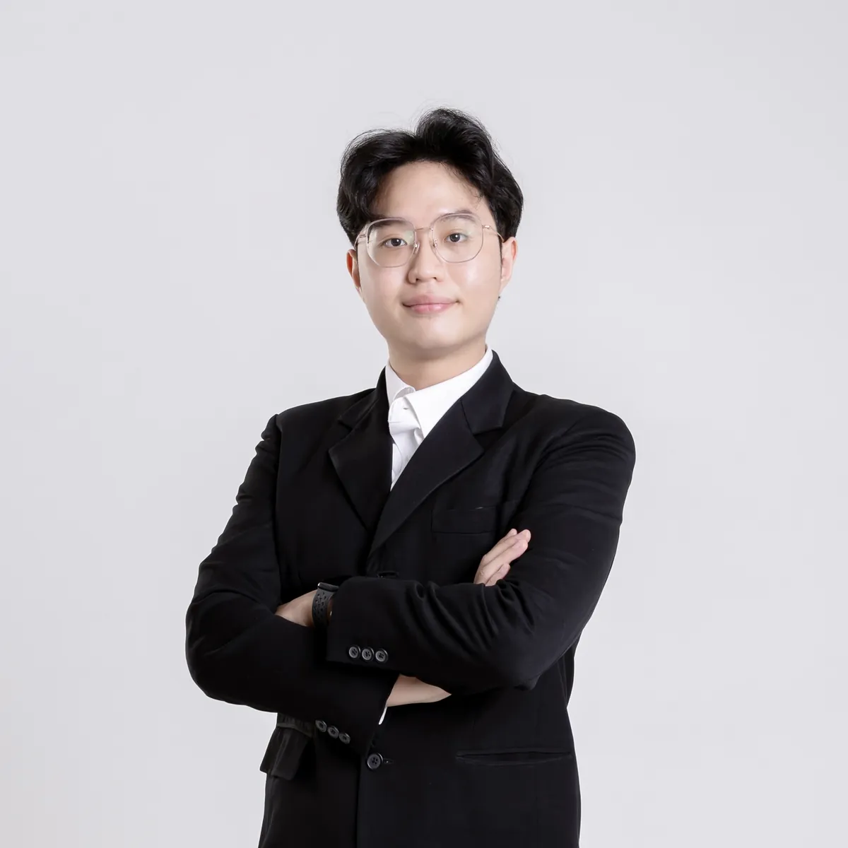 Worakorn Koonawootrittriron in a black suit, arms crossed